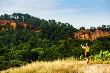 Woman take photo from red rocks in Roussillon, Provence France - obrazy, fototapety, plakaty
