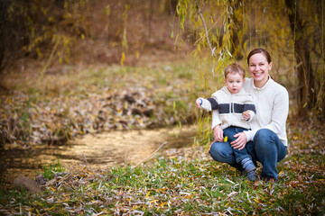 Young mother with son in autumn park