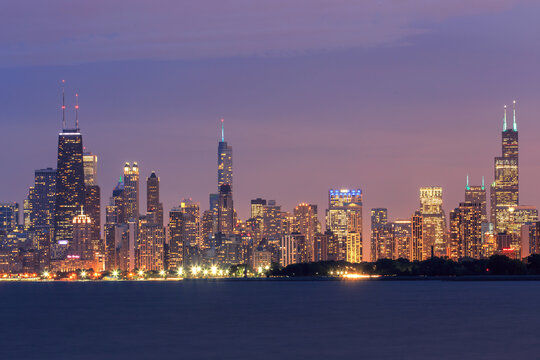 The Chicago skyline and waterfront at night with illuminated buildings in Lake Michigan	