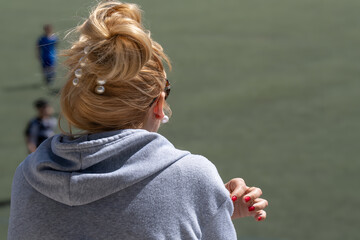 blonde girl with her back turned and her hair tied back