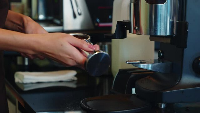 Fresh tasty coffee brewed by coffee machine in cafe or pub. Step by step guide to professional coffee making. Close up of machine hand holding handle pouring espresso.