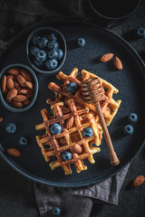 Sweet and delicious dark waffles with chocolate, berries and almonds.
