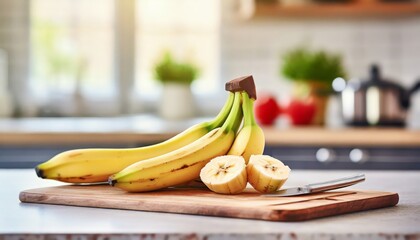 A selection of fresh fruit: bananas, sitting on a chopping board against blurred kitchen background; copy space
 - Powered by Adobe