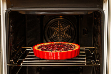 Closeup homemade berry pie baked in a home oven. Shallow focus.
