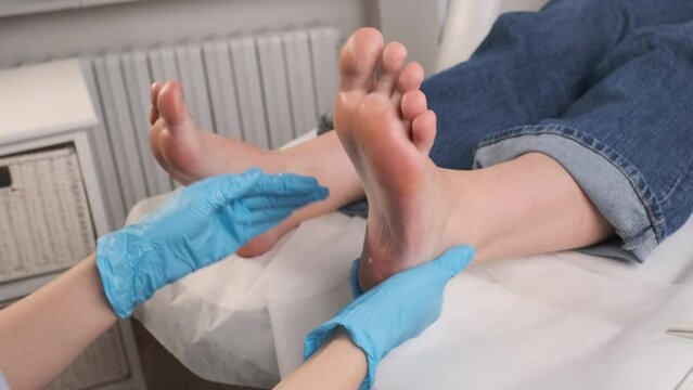 Woman undergoes the massage of feet in beauty salon. 