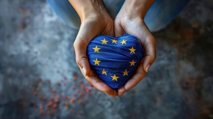 A pair of hands holding a heart-shaped object wrapped in the European Union flag, Europe Day