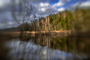 Landscape by a small lake in a forest in podlasie on a sunny,spring day with a blurred background.