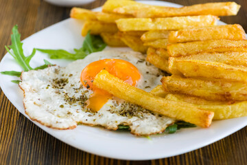 fries with fried eggs - 784555172