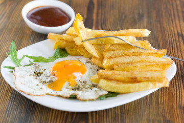 fries with fried eggs - 784555195