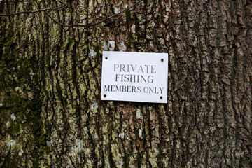 Private Fishing Sign Attached to a Tree Trunk in a Rural Location - 784557924