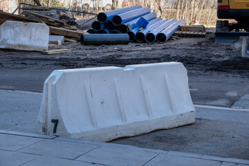 White plastic road barriers during the reconstruction and construction of a new street in the city