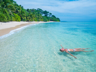 Serene tropical getaway woman relaxing in clear blue waters