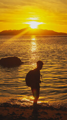 Silhouette of a Man Standing on the Beach at Sunrise