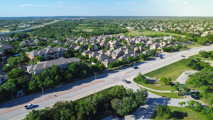Large park busy car parking near Brushy Creek Road, row of two story single family houses,...