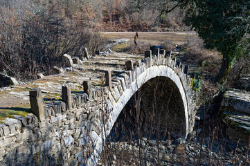View of the traditional stone Kapetan Arkouda bridge near the village of Kipi in Zagori of Epirus, Greece. - 784567564