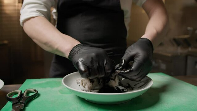 Italian Chef Hands Are Cleaning A Squid To Obtain Black Ink Juice