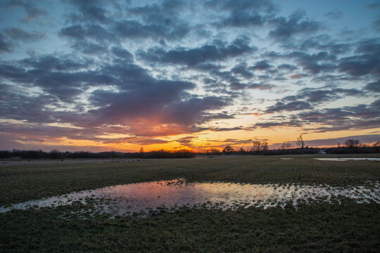 Sunset over wet meadow, evening March view