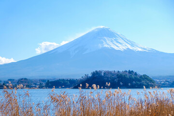 Fototapeta premium A distant view on Mt Fuji in Japan on a clear,The top parts of the volcano are covered with a layer of snow.