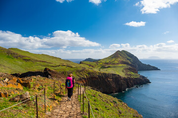 Tourists on hiking path on Ponta de Sao Lourenco Madeira Portugal. Green landscape cliffs and Atlantic Ocean. Ative day, travel background