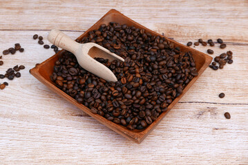 Eine Holzschale mit gerösteten Kaffeebohnen.