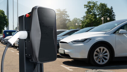 Electric vehicles charging station on a background of a row of cars. Concept