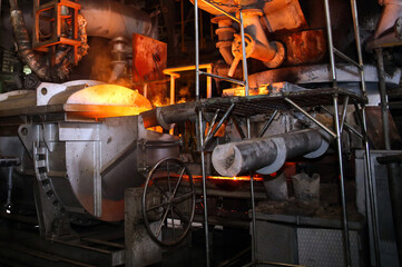 Steel mill Molten metal poured into mold, heavy machinery, metallurgy theme.