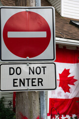 do not enter sign juxtaposed with a Canadian flag. concept of immigration, refugee and housing...