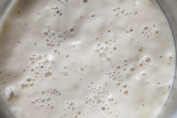 macro shot of bubbly sourdough starter in glass jar. Baking bread at home, fermented food