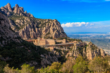 View of the famous Santa Maria de Montserrat Abbey located on the mountain of Montserrat nearby from Barcelona in Catalonia, Spain. Montserrat Monastery - obrazy, fototapety, plakaty