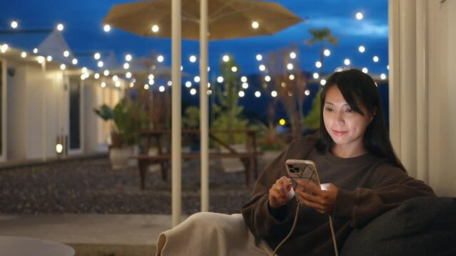 Woman use mobile phone at outdoor cafe