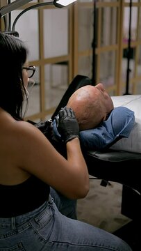 Man in a tattoo studio receiving a capillary or scalp microblading treatment