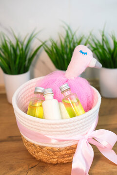 Children's cosmetics, bath accessories and toys in wicker basket in bright bathroom. Children's cosmetics concept. Vertical photography.