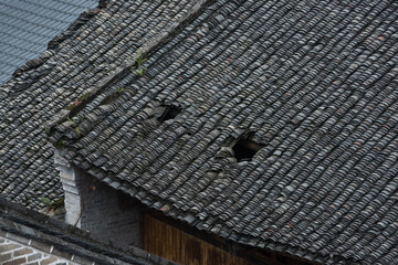 Holes in the tiled roof of an old Chinese house