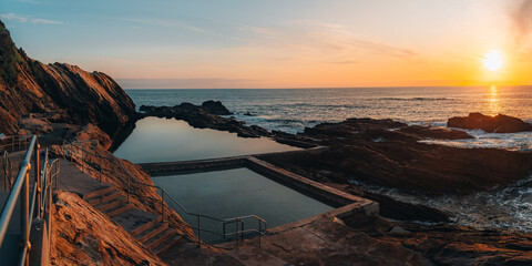 Aerial drone view of Blue Pool in Bermagui during sunrise sunset with blue sky and reflection. New...