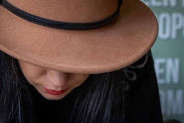 A woman wearing red lipstick and a brown hat in a Rotterdam coffee house