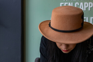 A woman wearing red lipstick and a brown hat in a Rotterdam coffee house