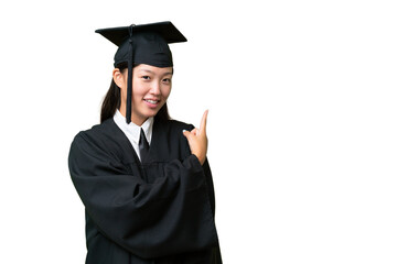 Young university graduate Asian woman over isolated background pointing back
