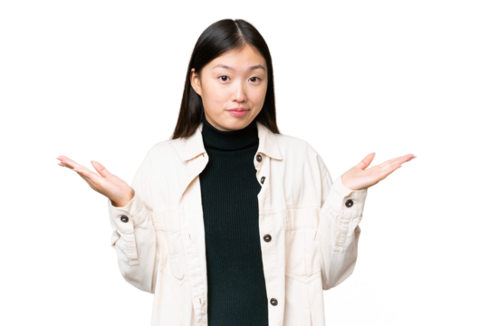 Young Asian woman over isolated chroma key background making doubts gesture