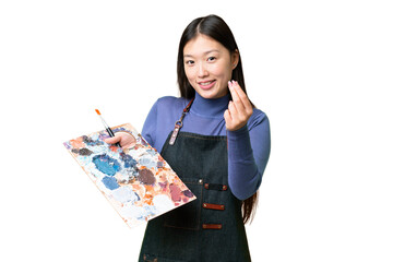 Young artist woman holding a palette over isolated chroma key background making money gesture