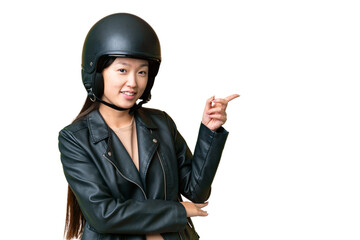 Young Asian woman with a motorcycle helmet over isolated chroma key background pointing finger to...