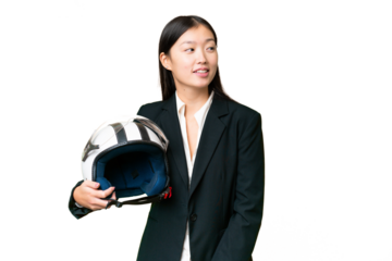 Young Asian woman with a motorcycle helmet over isolated chroma key background looking to the side and smiling