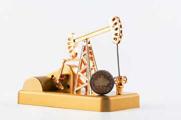 Golden oil pump and 1000 Uzbek sum coin on a white background