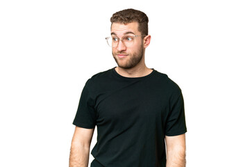 Obraz premium Young handsome blonde man over isolated chroma key background making doubts gesture looking side