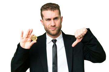 Young business blonde man holding a Bitcoin over isolated chroma key background showing thumb down...