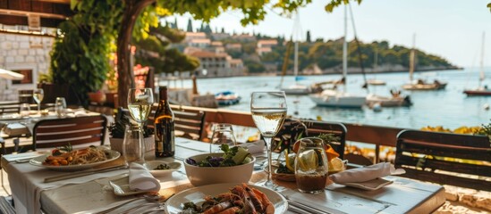 Fresh seafood dishes and local wines highlight the culinary offerings of Croatian coastal cafes.  - obrazy, fototapety, plakaty