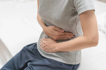 Tuinposter Flatulence ulcer, asian young woman, girl hands in belly, stomach pain from food poisoning, abdominal pain and digestive problem, gastritis or diarrhea. Abdomen inflammation, menstrual period people. © KMPZZZ