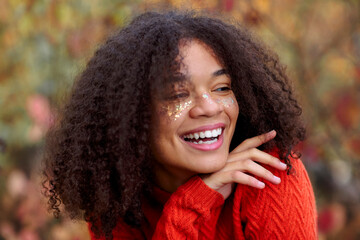 Young happy overjoyed african american woman with curly hair keeping eyes closed laughing and...
