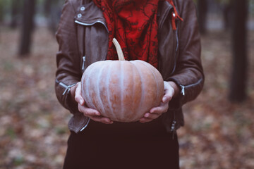 Woman holding big orange pumpkin