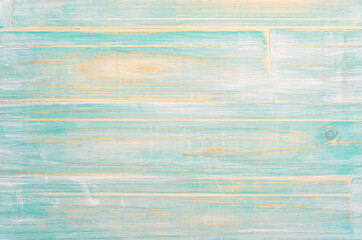 Joined wooden planks with a very marked grain and worn turquoise color.