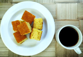 Pieces of traditional brazilian cake with black coffee on the rustic background made of bamboo